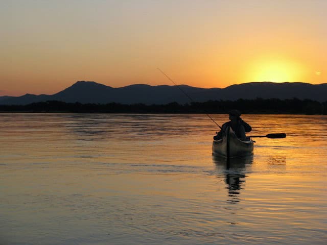 Fisherman in a canoe on Zambezi River, Zambia