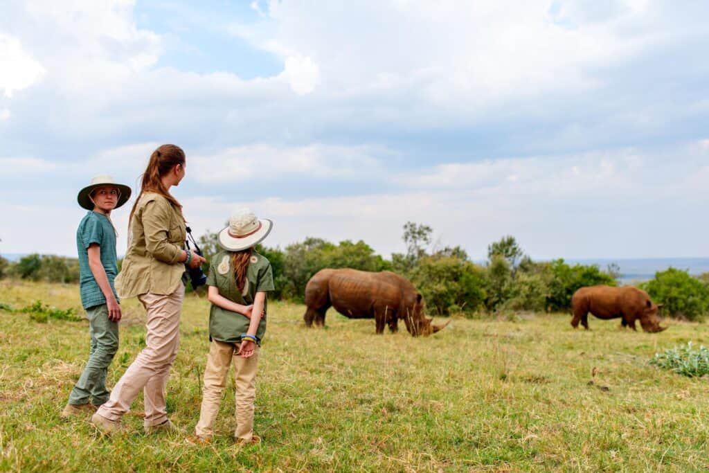 Family on a walking safari viewing black rhino
